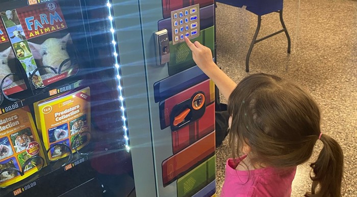 Student Selects Book from Book Vending Machine